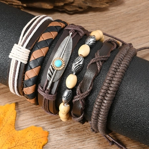 Detail of bohemian multilayer leather bracelets with turquoise feather pendant and beads