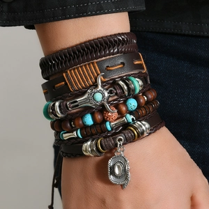 Gros plan de bracelets en cuir multicouches avec breloques tête de taureau et chapeau