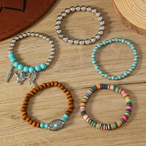 Five-piece Bohemian beaded bracelet set with turquoise charms and wood beads on wood background