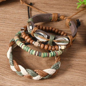 Détail de quatre bracelets bohèmes perlés avec coquillages et bois sur fond de bois