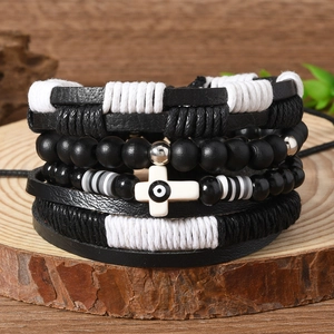 Gros plan détaillé du bracelet multicouche avec croix et œil grec sur support en bois