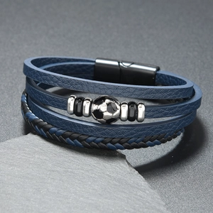 Macro view of multi-layer leather bracelet with soccer ball charm and magnetic clasp
