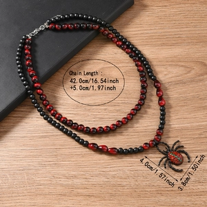 Gros plan d'un collier gothique en perles noires avec pendentif araignée et fermoir mousqueton