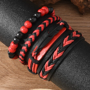 Détail d'un bracelet multicouche pour homme rouge et noir avec pendentif plume noire