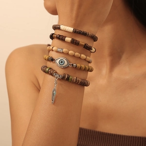 Nahaufnahme von Boho-Perlenarmband-Set mit Metallfeder und Evil-Eye-Anhängern