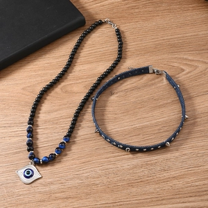 Bohemian evil eye bead necklace set with denim punk studded choker on wood background