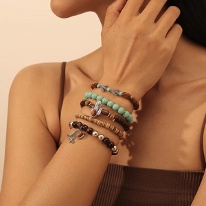 Detail eines fünfteiligen Boho-Perlenarmband-Sets mit Hamsa-Hand- und Kaktus-Anhängern