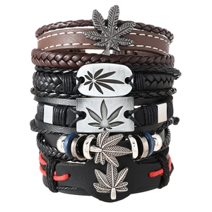 Close-up of stacked leather bracelets with alloy hemp leaf charms and blue bead accents
