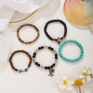 Detail von fünf Boho-Perlenarmbändern mit Fatima-Hand und Kaktusanhängern auf Stein
