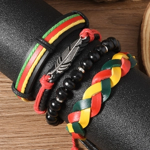Détail d'un lot de quatre bracelets bohèmes en cuir avec breloque plume sur support