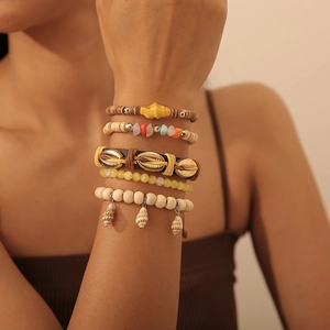 Details des 5-teiligen Bohemian-Armbandsets mit Muschelanhängern und Holzperlen am Handgelenk