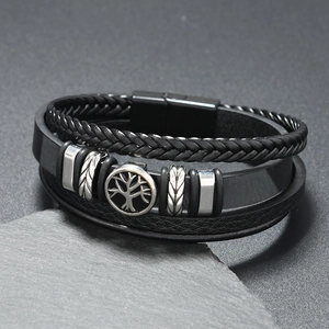 Detail of multi-layer leather bracelet featuring a silver Tree of Life charm and magnetic clasp