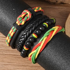 Détail de quatre bracelets multicouches de style Rastafari sur un support noir
