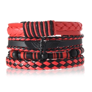 Détail de bracelets multicouches en cuir avec breloque aigle en métal et perles rouges