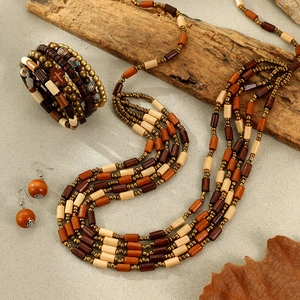 Bohemian multilayer wood bead necklace and bracelet set with cross pendant on stone surface