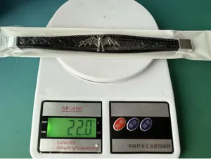 Detailansicht des geschichteten schwarzen Lederarmbands mit Silberfledermaus auf Waage