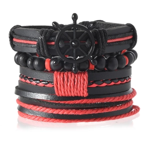 Détail d'un bracelet multicouche avec breloque gouvernail noir et cordon tressé rouge