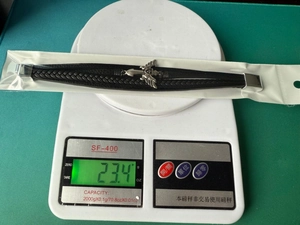 Detailed view of handmade gothic leather bracelet on scale weighing 23.4 grams