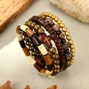 Detail of beaded vintage bracelet set with cross charm and feather pendant