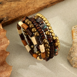 Close-up of vintage layered wooden beads bracelet with detailed metal feather pendant