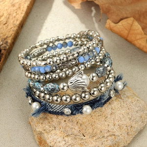 Detail of bohemian layered bracelet set featuring turquoise beads and silver tulip charm
