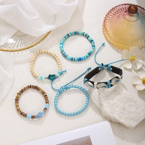 Set mit fünf Bohemian-Armbändern mit blauen Tonperlen, Holzperlen und Muschelanhänger