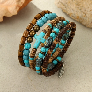 Detail of bohemian multilayer bracelet with turquoise beads, wooden tubes and feather charm