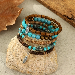 Detailed close-up of Bohemian multilayer beads bracelet with turquoise and silver feathers