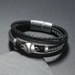 Détail macro du bracelet en cuir multicouche avec breloque baseball et fermoir magnétique