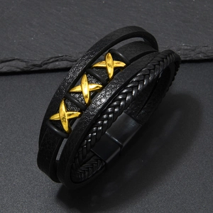Detail of multi-layer black leather bracelet featuring three golden X metal charms