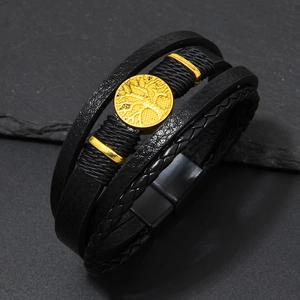 Macro shot of multi-layer men's leather bracelet with golden Tree of Life charm