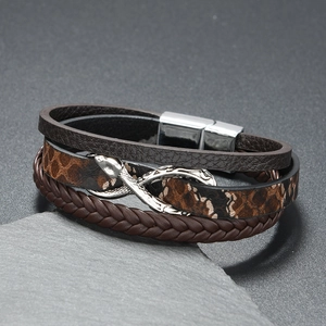 Close-up of men's multi-layer leather bracelet with silver snake head metal accent