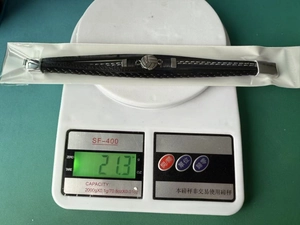 Détail montrant le poids de 21,3g d'un bracelet de football en cuir multicouche sur une balance
