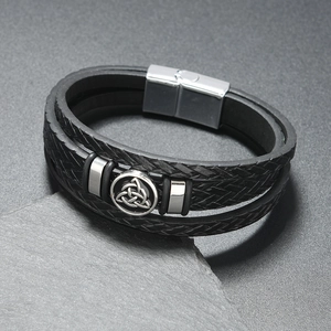 Détail macro du bracelet multicouche en cuir pour homme avec charme de nœud celtique argenté