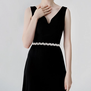 Gros plan d'une ceinture de mariée de luxe avec strass sur une robe noire élégante