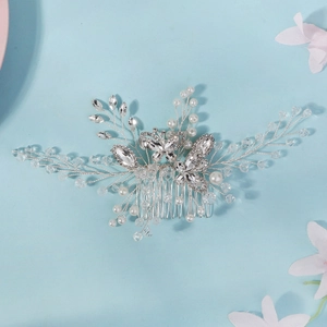 Detail showing bridal hair comb with crystal butterflies and pearls on blue backdrop