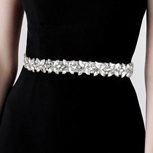 Detailed close-up of bridal belt with marquise and round crystals on formal dress