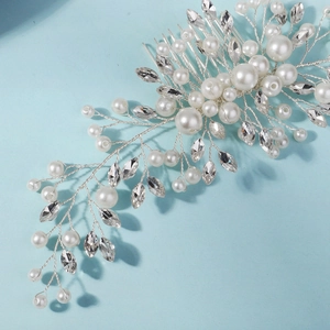 Close-up of handmade bridal hair comb with pearls and marquise rhinestones on blue