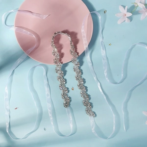 Ceinture de mariée luxueuse avec cristaux scintillants et rubans blancs sur fond doux