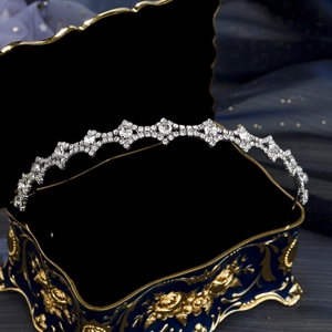 Dettaglio di un cerchietto in strass argento su un portagioie vintage blu e oro lucido