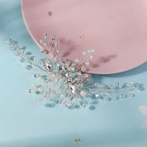 Detailed macro of silver bridal hair comb with crystal butterfly, rhinestones, and pearls