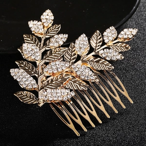 Détail du peigne à cheveux de mariée avec feuilles dorées et cristaux sur socle noir