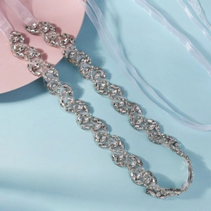 Détail de ceinture de mariée en strass marquise et ronds avec ruban en satin blanc soyeux