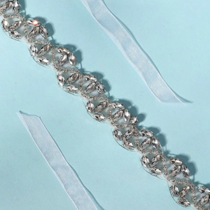 Détail d'une ceinture de mariée avec strass marquise et rubans en satin bleu clair