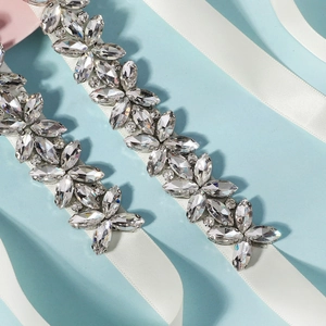 Macro detail of bridal belt featuring marquise rhinestones on white satin ribbon