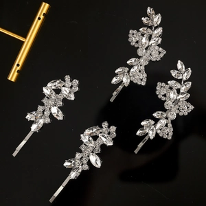 Détail de quatre barrettes argentées en strass avec motifs de feuilles et de fleurs