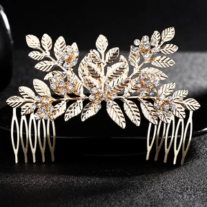 Détail d'un peigne à cheveux de mariée feuille dorée avec strass blancs sur fond noir