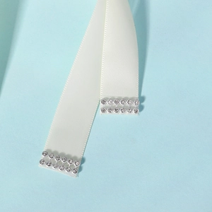 Detailed close-up of white satin bridal sash featuring hand-sewn marquise rhinestones