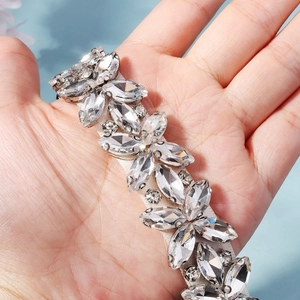 Macro detail of hand-sewn crystal bridal belt showing intricate marquise rhinestone patterns