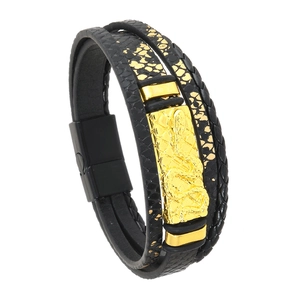 Detail eines mehrlagigen Lederarmbands mit goldenem Schlangensymbol und Magnetverschluss